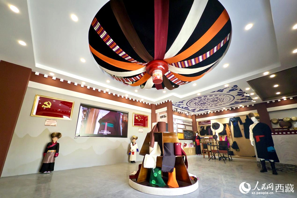 图为克西氆氇文化传承馆内部，穹顶设计色彩斑斓，展陈着精美的传统服饰与文创产品。人民网记者 次仁罗布摄